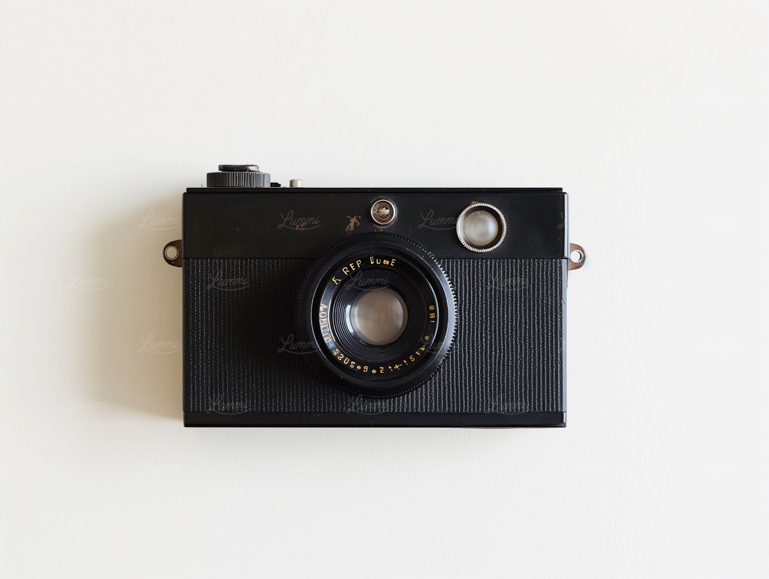 A vintage film camera photographed as a still life on a pale background